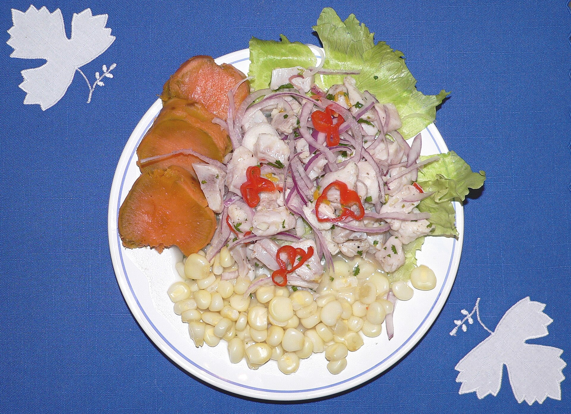 Ceviche peruano servido con camote, choclo y leche de tigre