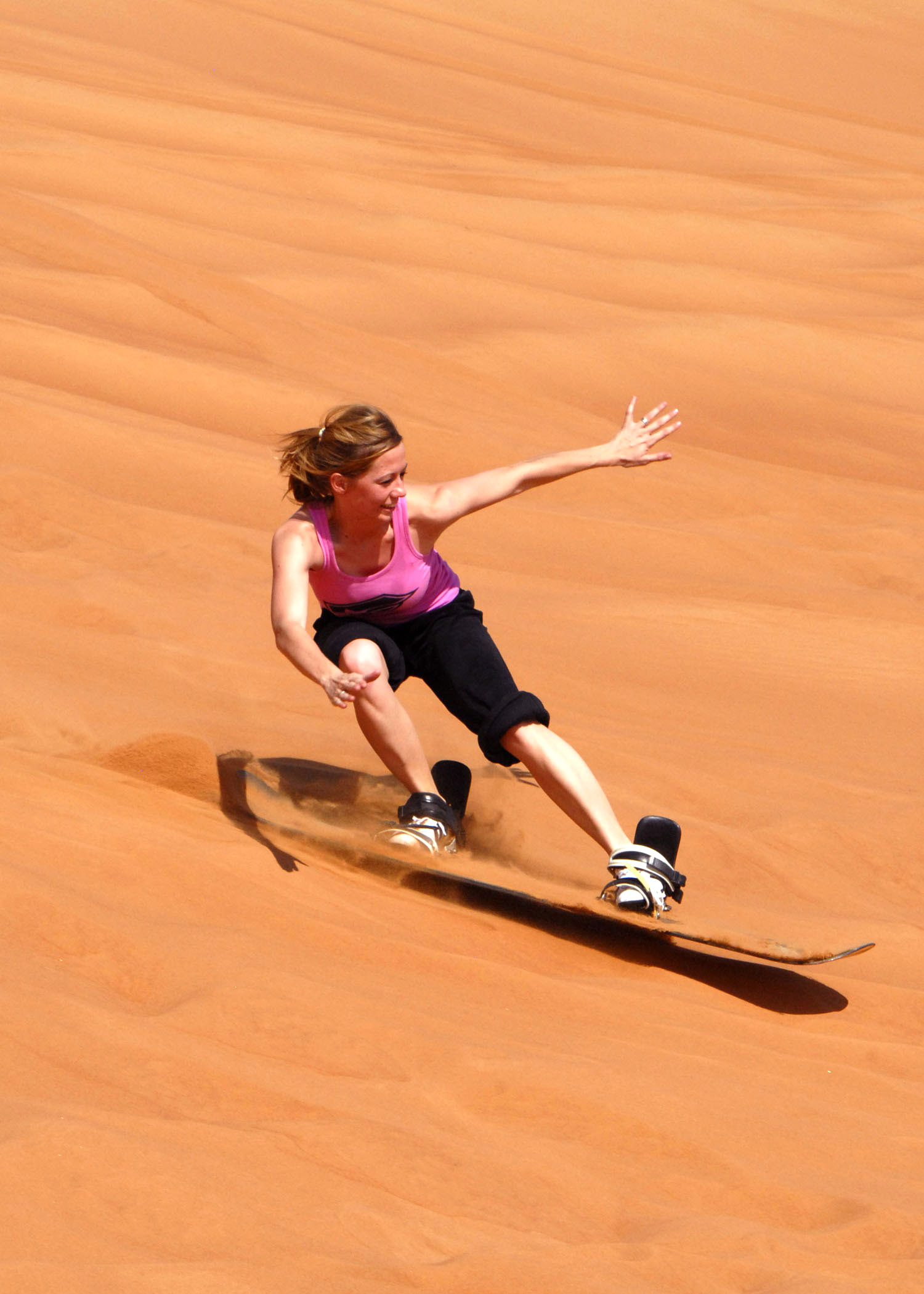 Viajeros practicando sandboarding en las dunas de Ica